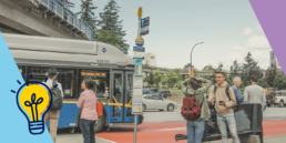 People waiting at a bus stop near King George Station, with the SkyTrain in the background