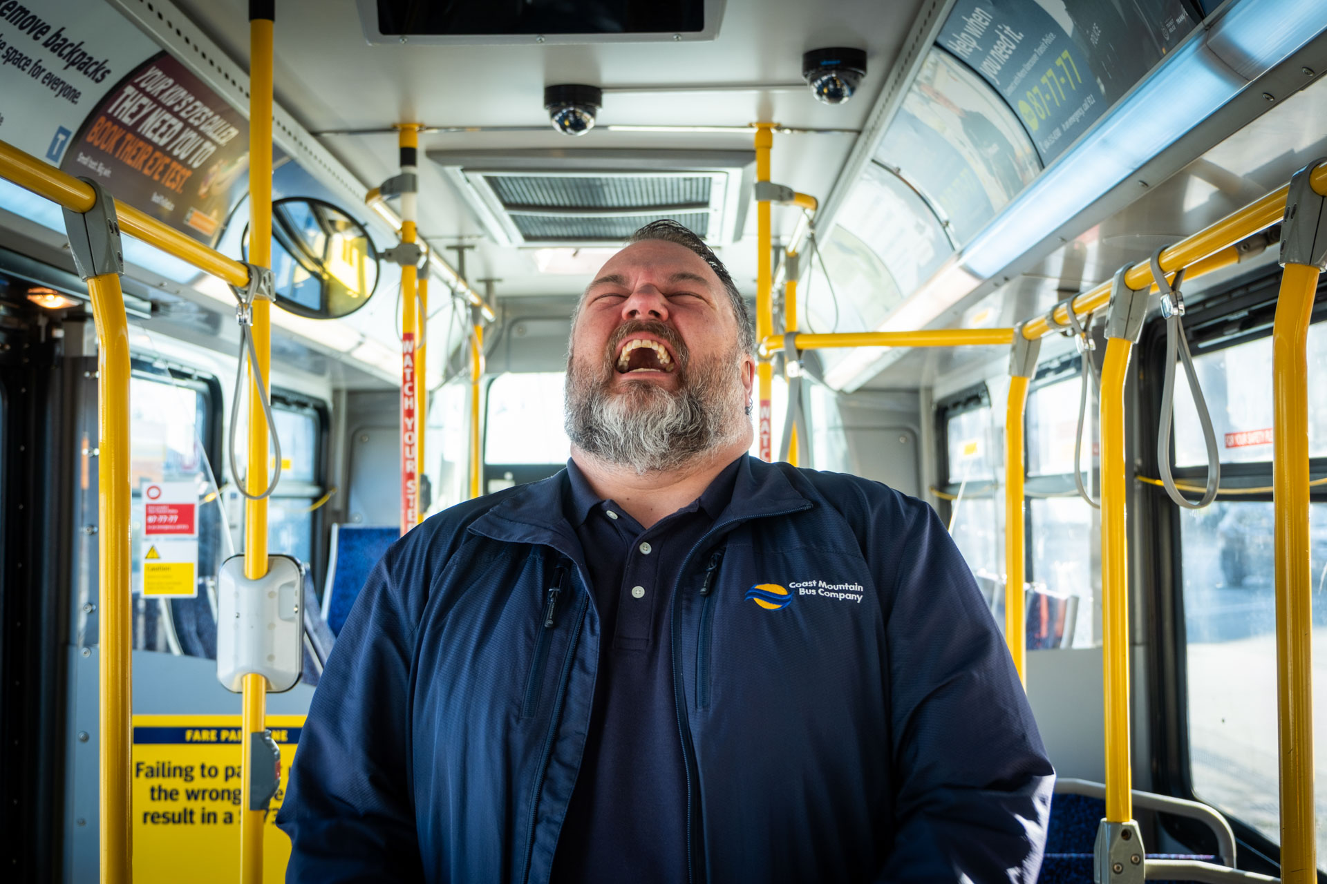 Bus operator Kelly Podlubny laughing inside a bus
