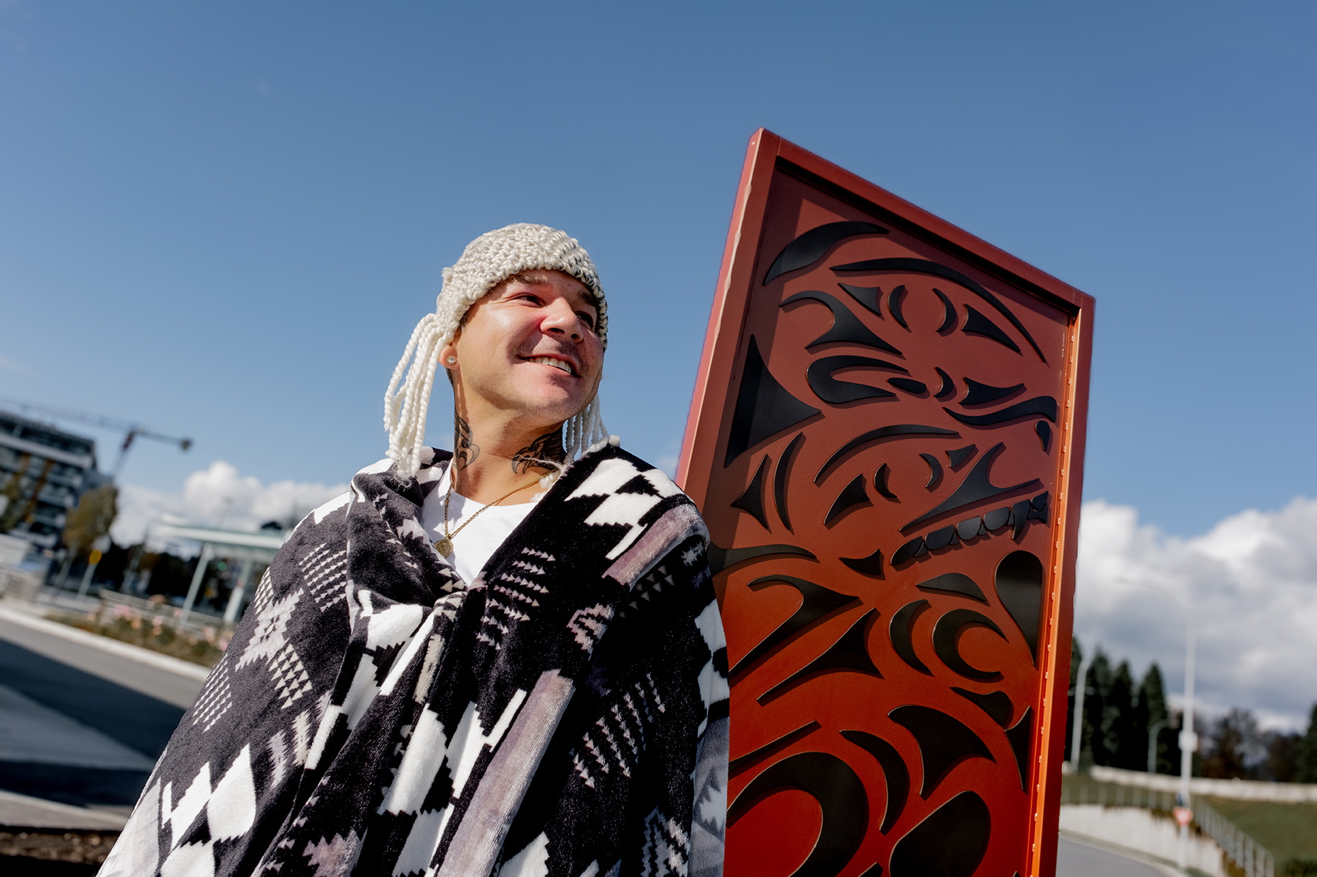 Indigenous artist Jordan Gallie stands in front of his art at Phibbs Exchange titled 'Perception and Integrity'