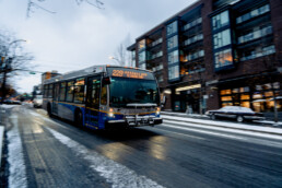 229 bus drives down Lonsdale in the winter with snow on the road