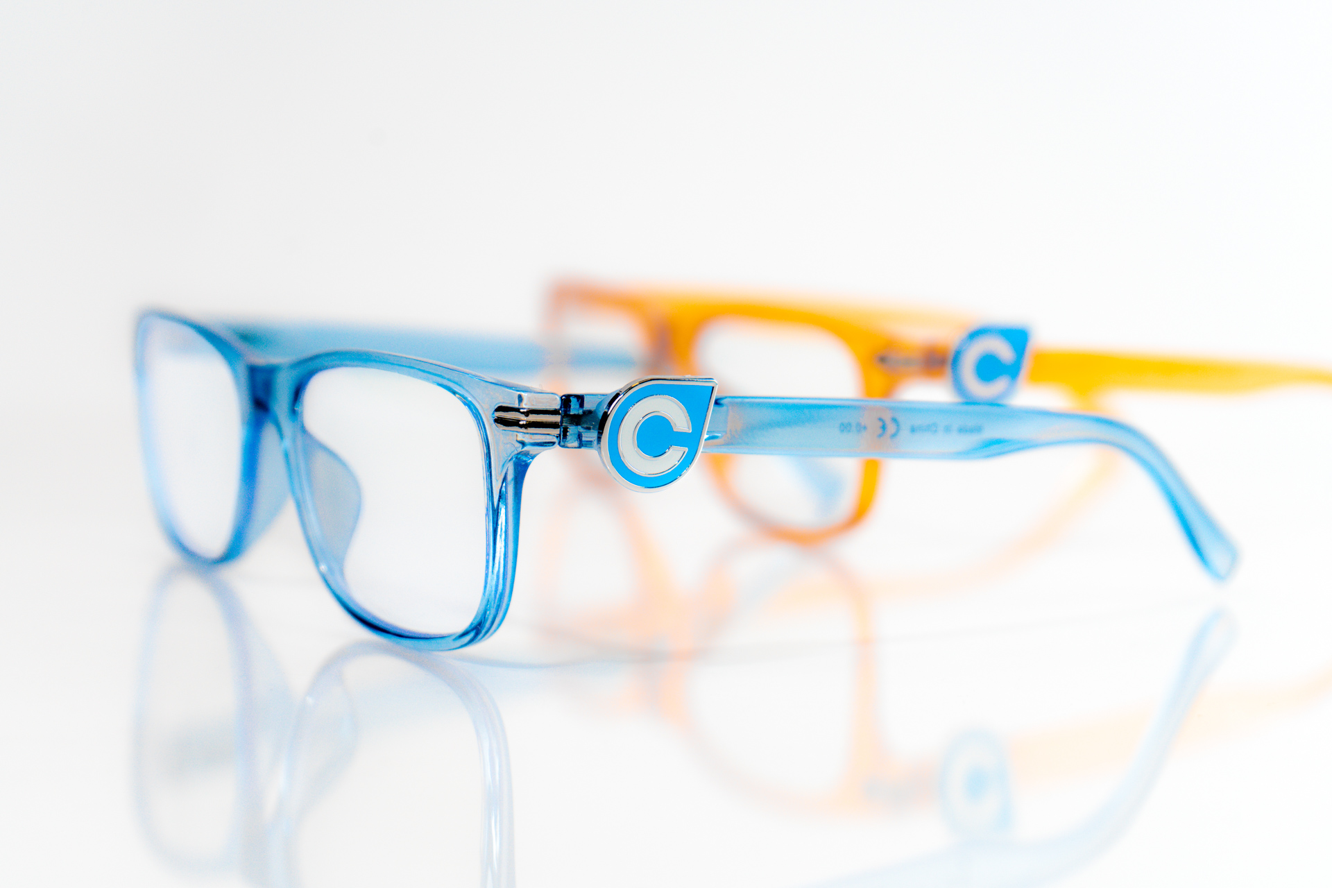 Translucent blue and orange Compass Glasses displayed on a white background, showing the frame details and Compass logo.
