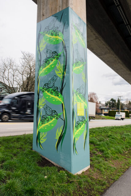 “Leaping into Change” by Gracielene Ulu, a SkyTrain pillar artwork showing frogs on leafy forms in shades of green along Stewardson Way.