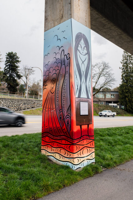 Painted SkyTrain pillar artwork showing seagulls, flowing water, and eulachon imagery in red, blue, and black along Stewardson Way in New Westminster.