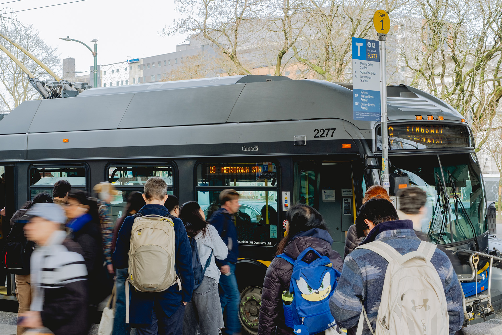 Transit riders board the 19 Kingsway to Metrotown Station bus at Main Street–Science World Station.