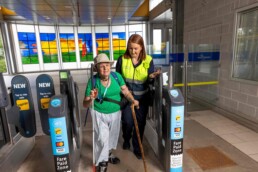 An STA helps a passenger through the fare gates.
