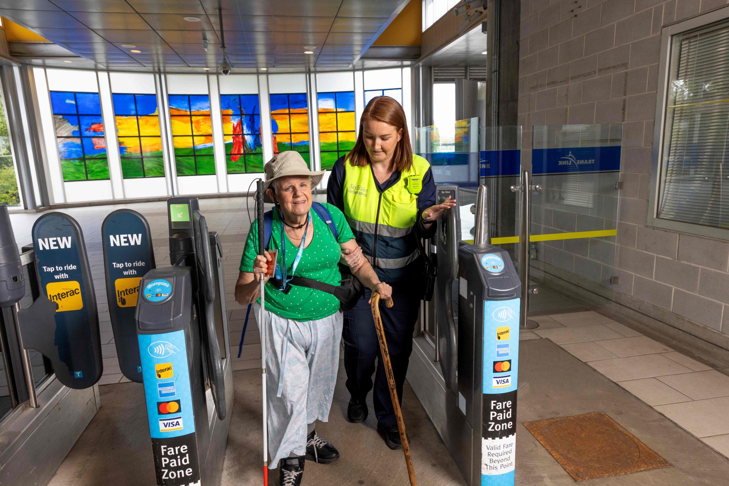 An STA helps a passenger through the fare gates.