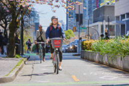 Lady rides a Mobi ike on a protected bike lane