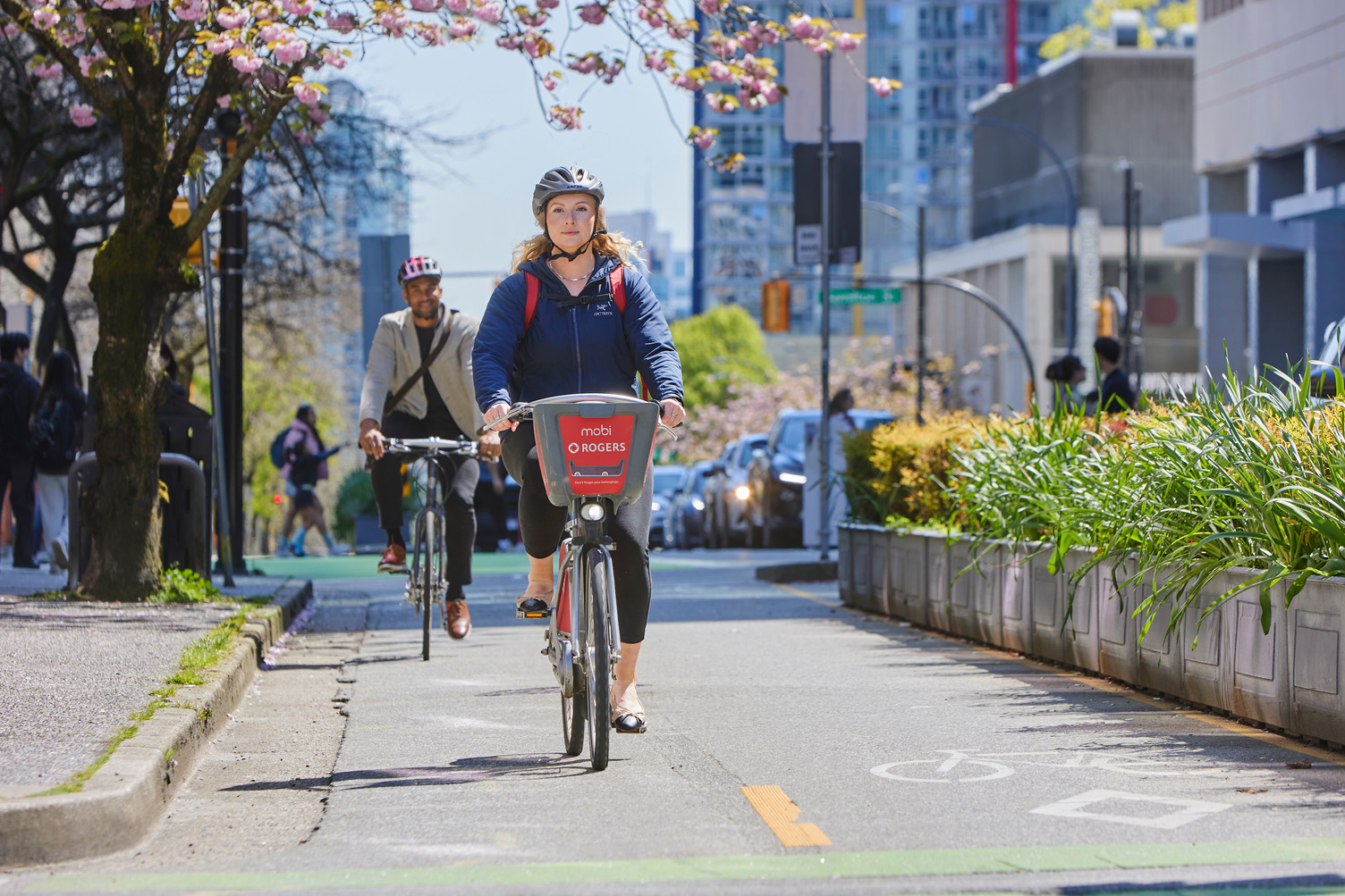 Lady rides a Mobi ike on a protected bike lane