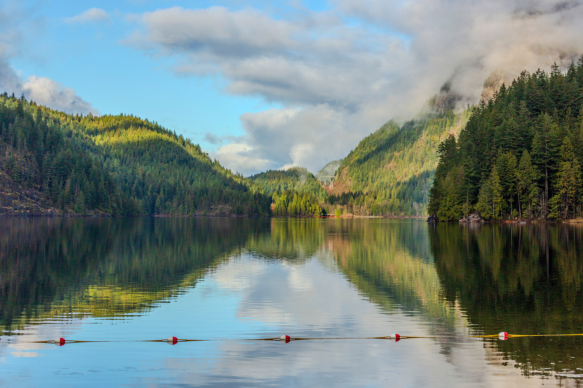 Serene Buntzen lake mirrors the surrounding mountains and forest